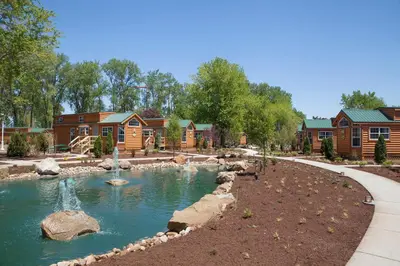a park with a pond in front of a lodge at Cedar Point's Lighthouse Point in Sandusky