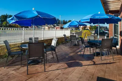 a group of tables and chairs with blue umbrellas at Fairfield Inn & Suites by Marriott Akron Stow in Stow