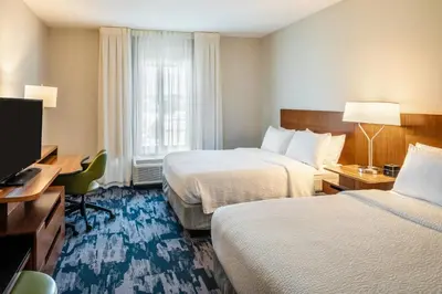 a hotel room with two beds and a flat screen tv at Fairfield Inn & Suites by Marriott Akron Stow in Stow