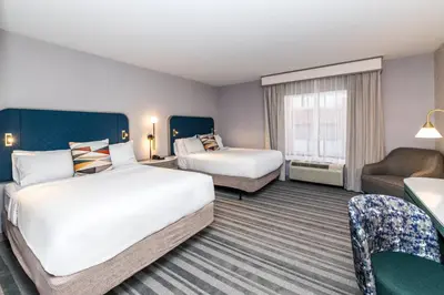 a hotel room with two beds and a couch at Voco The Clair Cincinnati Downtown by IHG in Cincinnati