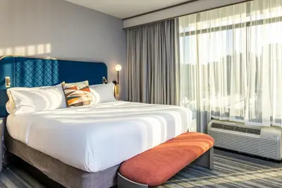 a bedroom with a large bed and a large window at Voco The Clair Cincinnati Downtown by IHG in Cincinnati