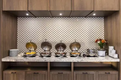 a buffet with bowls of food on a counter at Voco The Clair Cincinnati Downtown by IHG in Cincinnati