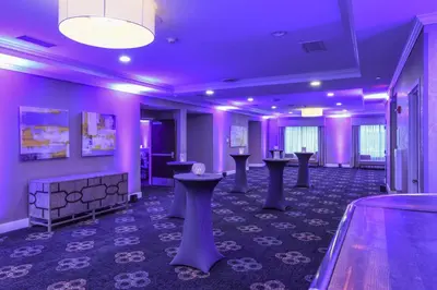 a room with purple walls and tables and a bowling alley at Voco The Clair Cincinnati Downtown by IHG in Cincinnati