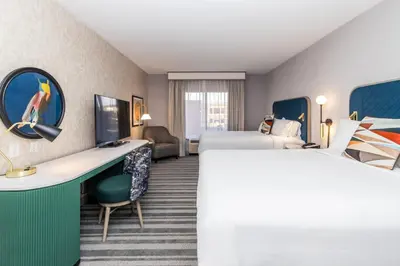 a hotel room with two beds and a desk at Voco The Clair Cincinnati Downtown by IHG in Cincinnati