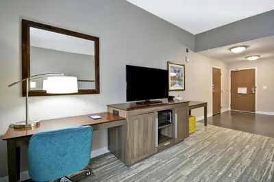 a room with a desk with a television and a chair at Hampton Inn Blue Ash/Cincinnati, OH in Blue Ash