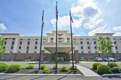 a hotel with two flags in front of a building at Hampton Inn Blue Ash/Cincinnati, OH in Blue Ash