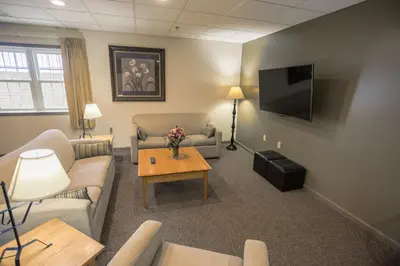 a living room with couches and a tv and a table at Lodging on the Square in Berlin