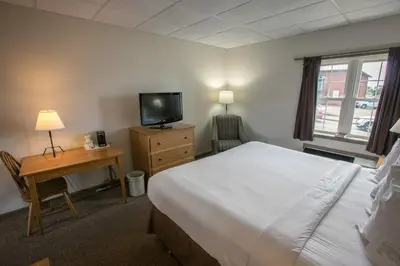 a bedroom with a bed and a desk and a television at Lodging on the Square in Berlin