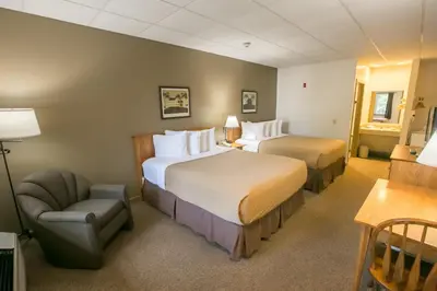a hotel room with two beds and a chair at Lodging on the Square in Berlin