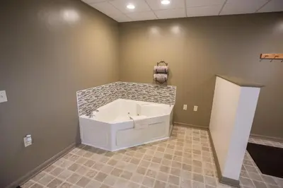 a bath tub in a room with a tile floor at Lodging on the Square in Berlin