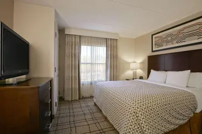 a hotel room with a bed and a flat screen tv at Embassy Suites Cleveland - Beachwood in Beachwood