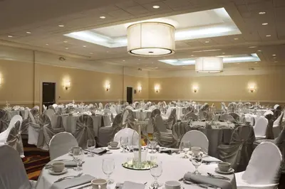 a banquet hall with white tables and white chairs at Embassy Suites Cleveland - Beachwood in Beachwood