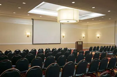 a conference room with a projector screen and chairs at Embassy Suites Cleveland - Beachwood in Beachwood