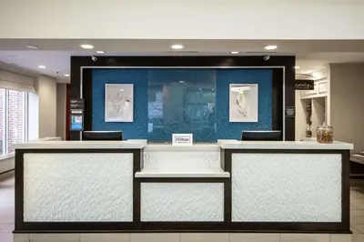 a lobby with a counter with three chairs in it at Hilton Garden Inn Columbus/Dublin in Dublin