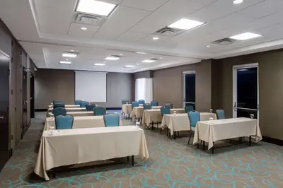 a conference room with tables and chairs and a screen at Hilton Garden Inn Columbus/Dublin in Dublin