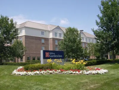 a sign in front of a building with flowers at Hilton Garden Inn Columbus/Dublin in Dublin