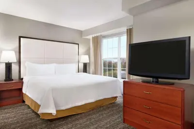a bedroom with a bed and a flat screen tv at Homewood Suites by Hilton Columbus-Dublin in Dublin
