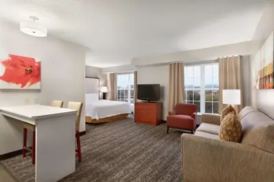 a hotel room with a bed and a couch and a television at Homewood Suites by Hilton Columbus-Dublin in Dublin