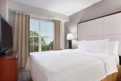 a bedroom with a large bed and a large window at Homewood Suites by Hilton Columbus-Dublin in Dublin