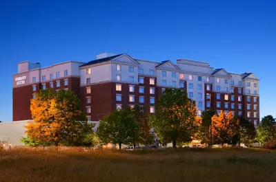 a large building with trees in front of it at Embassy Suites by Hilton Columbus Dublin in Dublin