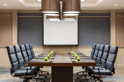 a conference room with a table and chairs and a screen at Embassy Suites by Hilton Columbus Dublin in Dublin