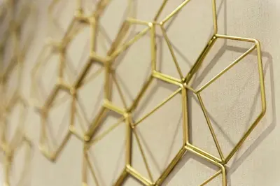 a bunch of gold metal structures on a wall at Embassy Suites by Hilton Columbus Dublin in Dublin