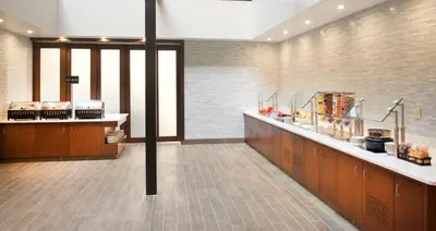 a large kitchen with wooden cabinets and a counter at Embassy Suites by Hilton Cincinnati Northeast - Blue Ash in Blue Ash