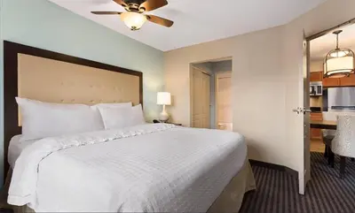 a bedroom with a large white bed with a ceiling fan at Homewood Suites by Hilton Columbus-Hilliard in Hilliard