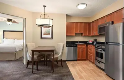 a kitchen with a table and a bed in a room at Homewood Suites by Hilton Columbus-Hilliard in Hilliard
