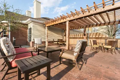 a patio with chairs and tables and a wooden pergola at Homewood Suites by Hilton Columbus-Hilliard in Hilliard