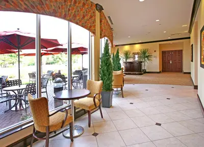 a lobby with a table and chairs and a patio at Hilton Garden Inn Cincinnati Blue Ash in Blue Ash