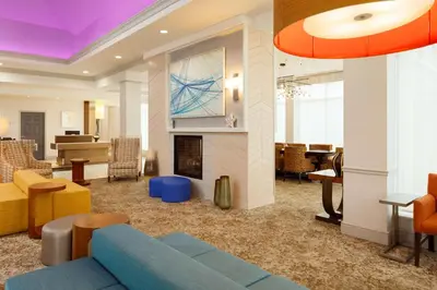 a living room with a blue couch and a fireplace at Hilton Garden Inn Cincinnati Blue Ash in Blue Ash