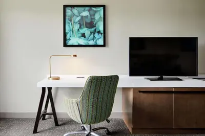 a desk with a computer monitor and a chair at Hilton Garden Inn Cincinnati Northeast in Loveland