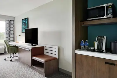 a hotel room with a desk with a computer at Hilton Garden Inn Cincinnati Northeast in Loveland