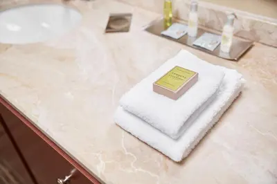 a book sitting on top of a towel on a bathroom counter at DoubleTree Suites by Hilton Hotel Cincinnati - Blue Ash in Sharonville
