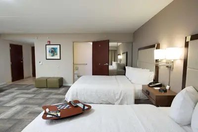 a hotel room with two beds and a purse at Hampton Inn & Suites Cincinnati-Union Centre in West Chester