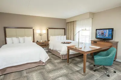 a hotel room with two beds and a desk and a television at Hampton Inn & Suites Cincinnati-Union Centre in West Chester