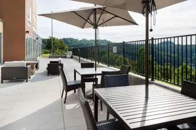 a patio with tables and chairs and an umbrella at Fairfield Inn & Suites by Marriott Huntington in Huntington