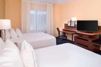 a hotel room with two beds and a desk with a computer at Fairfield Inn & Suites by Marriott Huntington in Huntington