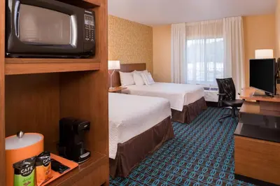 a hotel room with two beds and a tv at Fairfield Inn & Suites by Marriott Huntington in Huntington