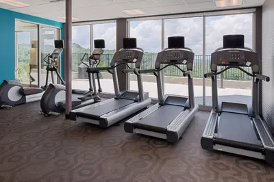 a row of treadmills in a gym with windows at Fairfield Inn & Suites by Marriott Huntington in Huntington