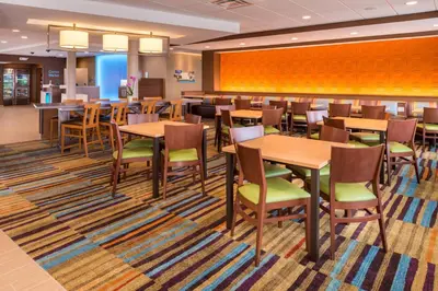 a dining room with wooden tables and chairs at Fairfield Inn & Suites by Marriott Huntington in Huntington