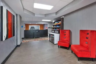 a waiting room with two red chairs and a tv at Hampton Inn Columbus/Delaware I-71 North in Sunbury