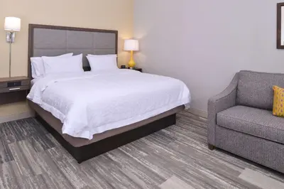 a hotel room with a bed and a chair at Hampton Inn & Suites Cincinnati-Mason, Ohio in Mason