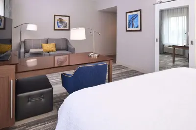 a hotel room with a bed and a desk and a couch at Hampton Inn & Suites Cincinnati-Mason, Ohio in Mason