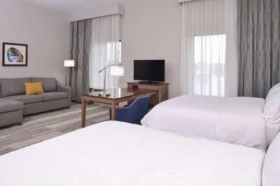 a hotel room with two beds and a couch at Hampton Inn & Suites Cincinnati-Mason, Ohio in Mason