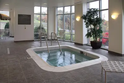 a hot tub in the middle of a room with windows at Hampton Inn & Suites Pittsburgh-Meadow Lands in Washington