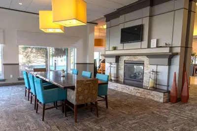 a dining room with a table and a fireplace at Hilton Garden Inn Pittsburgh/Southpointe in Canonsburg