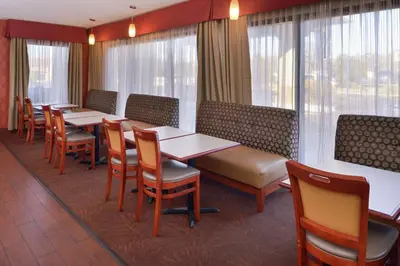 a restaurant with tables and chairs and windows at Hampton Inn Columbus-East in Pickerington