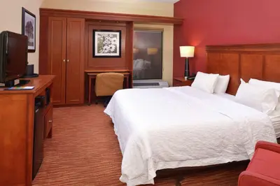 a hotel room with a bed and a flat screen tv at Hampton Inn Columbus-East in Pickerington